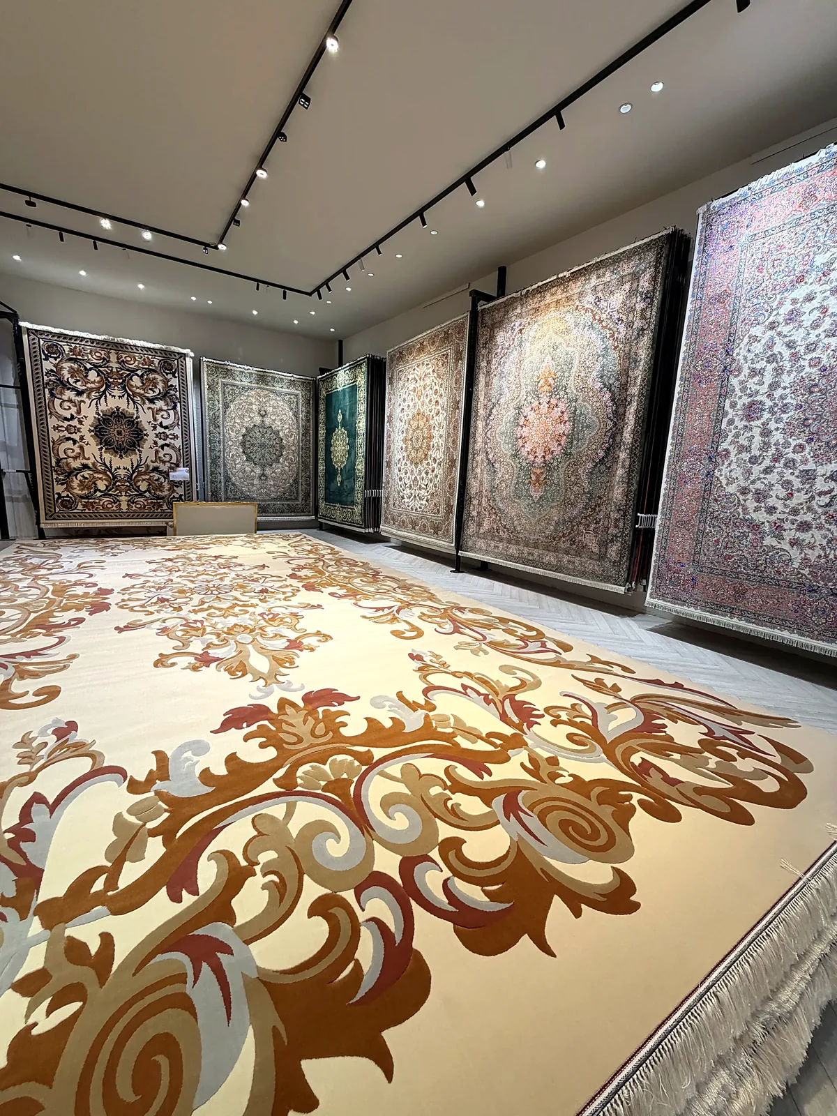 Large ivory carpet with hanging carpets behind